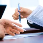 Conseiller financier échangeant des documents avec un client lors d'un rendez-vous