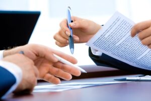 Conseiller financier échangeant des documents avec un client lors d'un rendez-vous