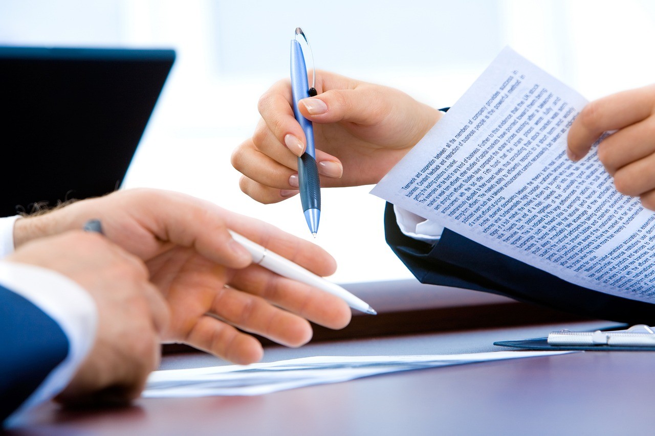 Conseiller financier échangeant des documents avec un client lors d'un rendez-vous