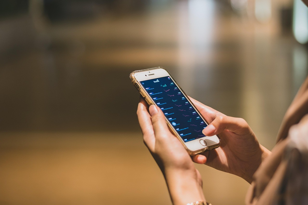 Personne consultant une application d'investissement sur son smartphone
