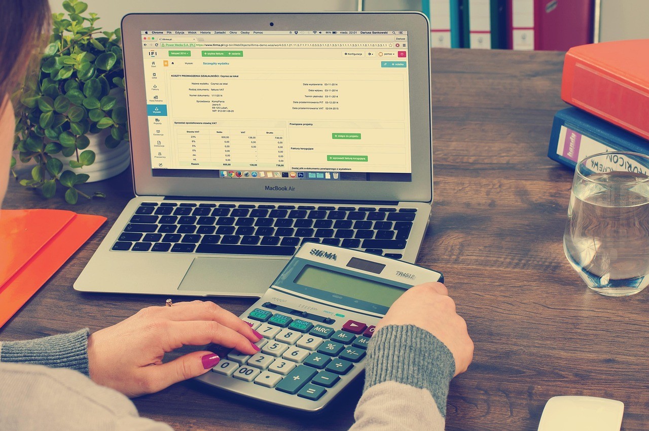 Calculatrice et documents comptables sur un bureau, illustrant le calcul de la fiscalité entre PEA et compte-titres