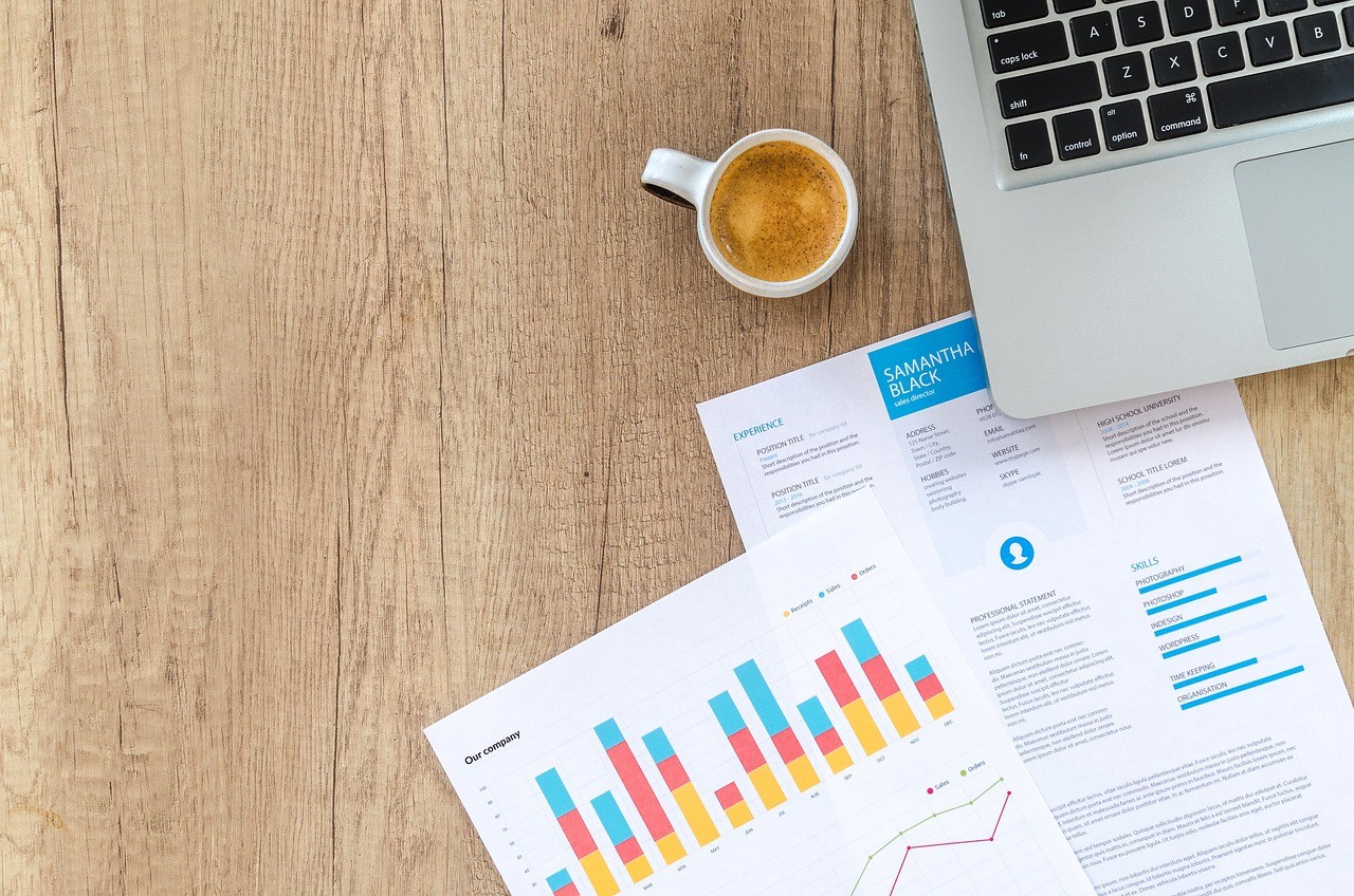 Comparaison de graphiques financiers sur un bureau, illustrant l'écart de frais entre trackers