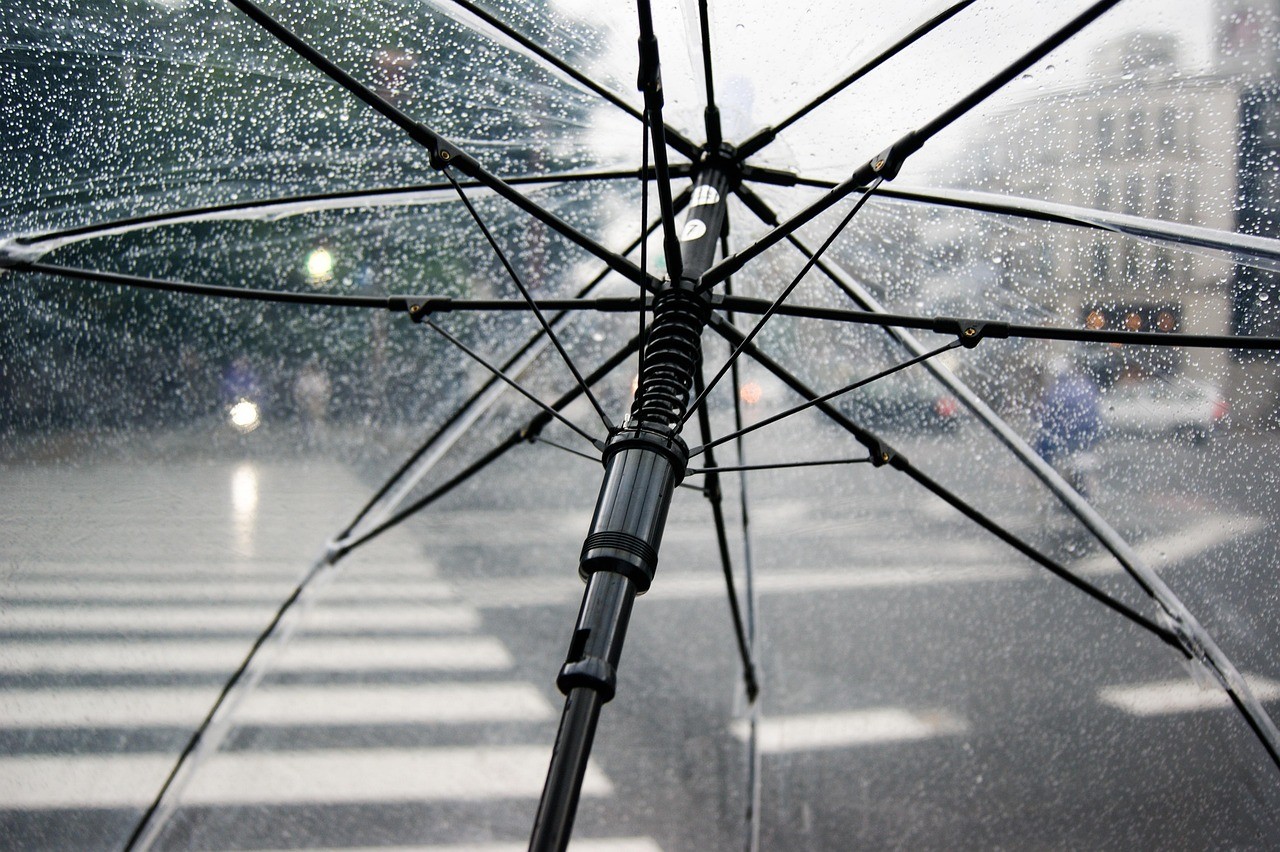Parapluie ouvert sous la pluie dans une rue, illustration de la corrélation entre deux événements