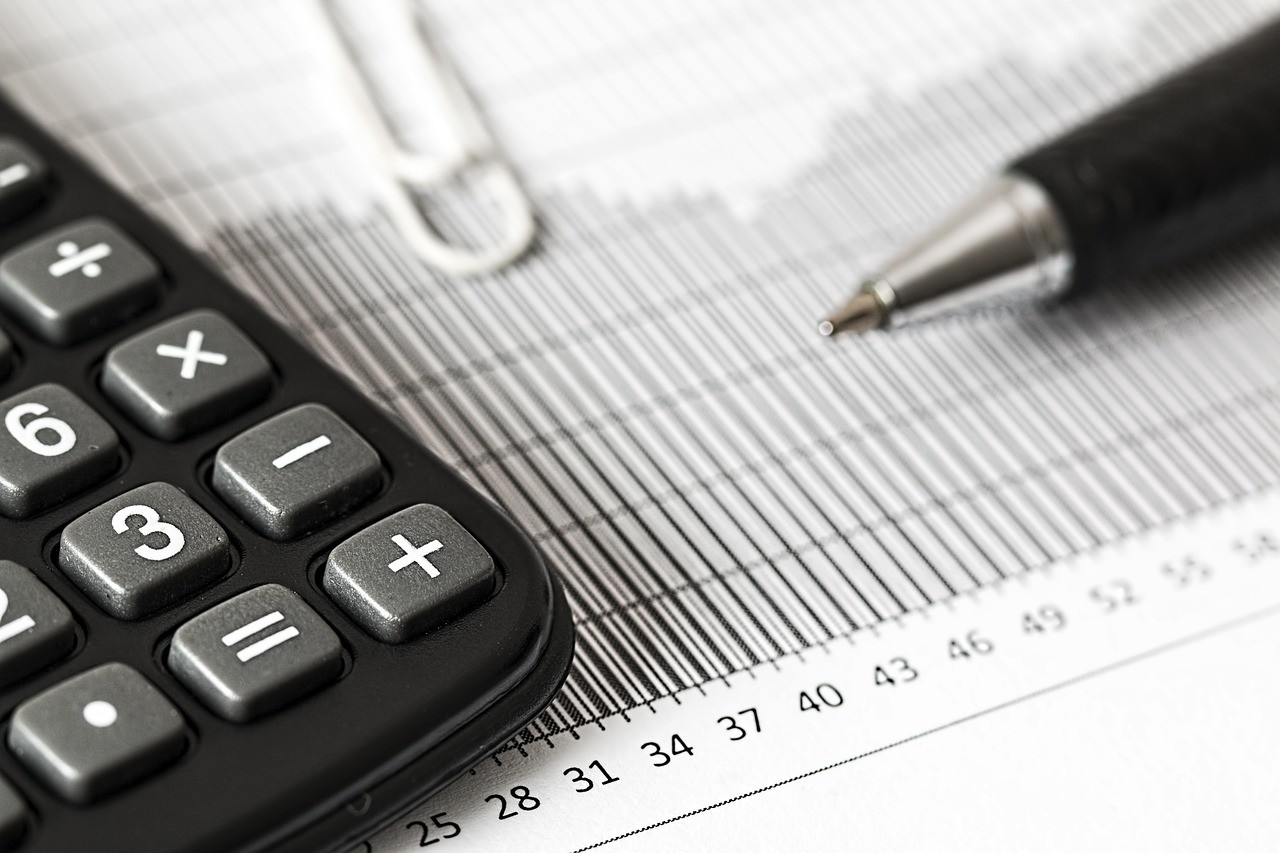Calculatrice posée sur un relevé de calcul avec des colonnes de chiffres, pour vérifier un avis d'imposition