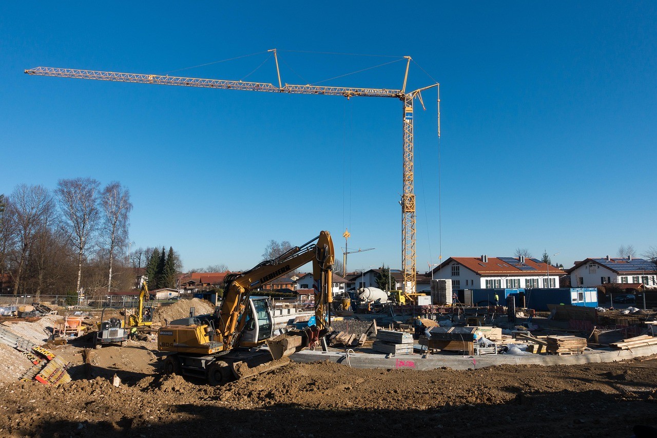 Chantier de construction avec grue et pelleteuse sur un programme immobilier neuf