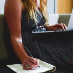 Personne prenant des notes avec un ordinateur portable pour planifier son épargne