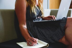 Personne prenant des notes avec un ordinateur portable pour planifier son épargne
