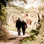 Couple de retraités marchant sur un sentier ensoleillé en pleine nature